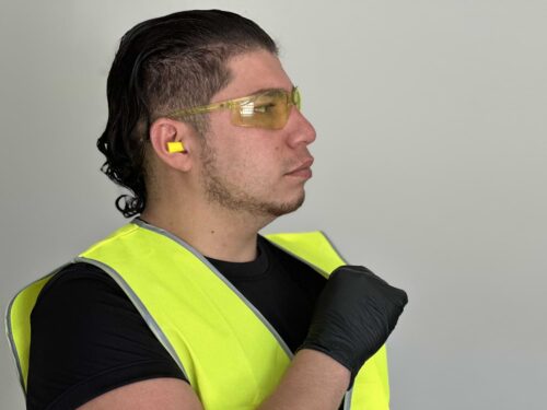 Tradie wearing Wave Bullet Earplugs and Hi-Vis Day Vest and Black Hog Nitrile Disposable Medical Grade Gloves or NexusFlex Nitrile Medical Grade Disposable Gloves from Your Safety Factory